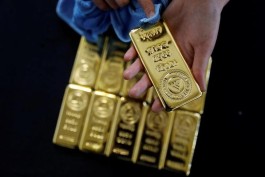 Gold falls under pressure from a stronger dollar, amid anticipation of new data that could deepen its losses.